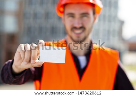 Medium shot portrait of construction engineer holding business card