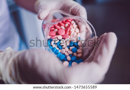 scientist doctor pours pills on his hand Royalty-Free Stock Photo #1473655589