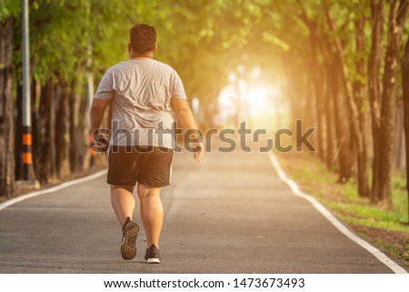 Exercise and healthy concept : Fat man running in the park Royalty-Free Stock Photo #1473673493