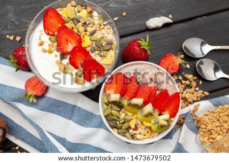 Oatmeal with yogurt and berries on a black wooden background. Top view. Healthy breakfast. 