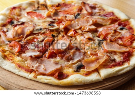 Hot tasty pizza on wooden board, close up