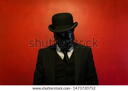 Well Dressed Man in Dark Suit With Black Plastic Bag Wrapped Around His Face. Concept of Horror Movie Monster. Dark Stock Photo. Copy Space for Nightmares