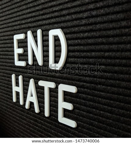 Text in English spelling End Hate against a black felt background. Selective focus and depth of field. 