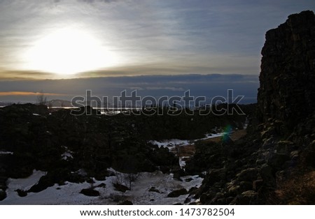 Typical Icelandic landscape: Thingvellir National Park, rivers, lava fields covered with snow against the backdrop of mountains and sky