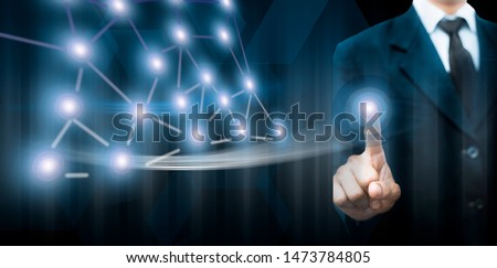 Entrepreneur/Businessman/technologist wearing a blue colored blazer and standing against a blue-colored digital virtual imaginative background and touching the virtual screen.
