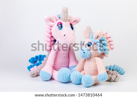 crocheted soft toy unicorn on a white background, amigurumi
