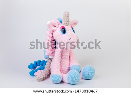 crocheted soft toy unicorn on a white background, amigurumi