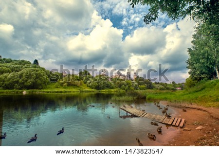 Ducks beach of Tverisa river on background Boris and Gleb monastery in Torzhok town, Tver region, Russia.