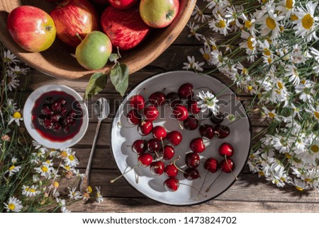 nice bright composition of ripe fruit: cherries and apples with wild flowers in different dishes. The concept of autumn mood. flat lay