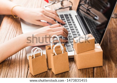 shopping online at home concept.Cartons in a shopping cart on a laptop keyboard.online shopping is a form of electronic commerce that allows consumers to directly buy goods from a seller over internet