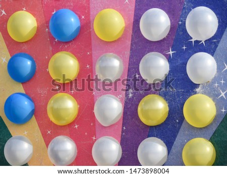 white and yellow balloons on the rainbow colored board