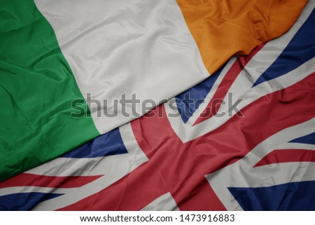 waving colorful flag of great britain and national flag of ireland. macro Royalty-Free Stock Photo #1473916883