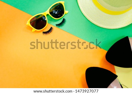 Woman's accessories lying flat on textured fabric background. Blue and yellow pastel colors with copy space around products. Horizontal image or photograph.