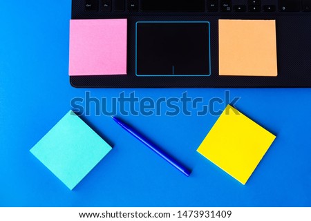 stickers for notes near the laptop on a blue background.