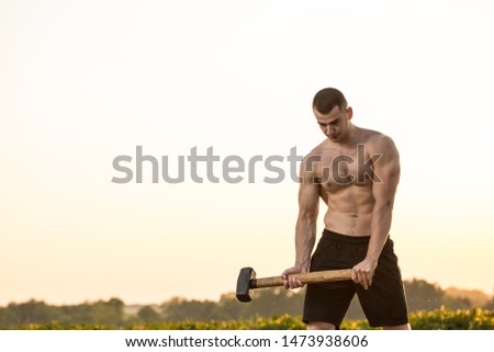 
strong pumped up man.man holds hammer.