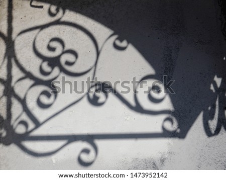 Solar glare and shadows on the wall from the leaves.