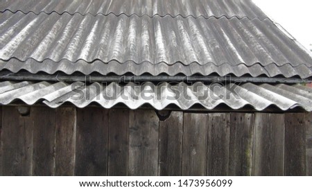 old barn made of dark gray slate and a wooden fence