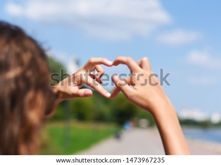 girl shows heart with hands