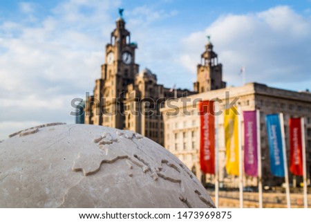Globe statue pictured in front of the Three Graces on the Liverpool waterfront.
