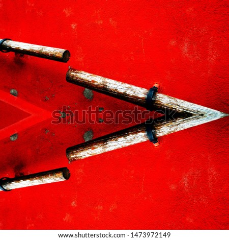 photographic patterns of wooden hand rail on a vivid red textured wall