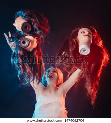 Concept of how difficult it is to be a woman. Portrait of model girl in the image of the bride surrounded by mannequin heads with a smile face think what decision to take close up view