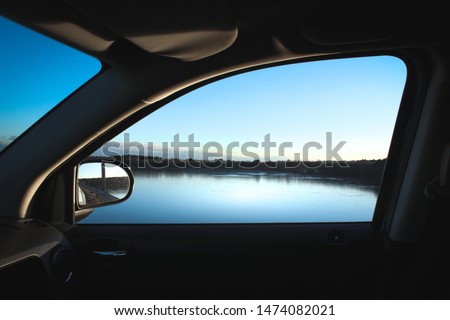 Looking out a car window at the Diamond Hill Reservoir in Cumberland, Rhode Island on a cod winter day in January. Royalty-Free Stock Photo #1474082021