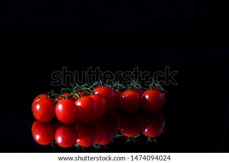 Sweet fresh tomatoes on a black background, close up, macro	photography, still life