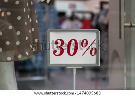 Season sale, black friday and shopping concept. Sale signs on stands in shop. Sale sign 30% percent discount price on stand in shop windows.