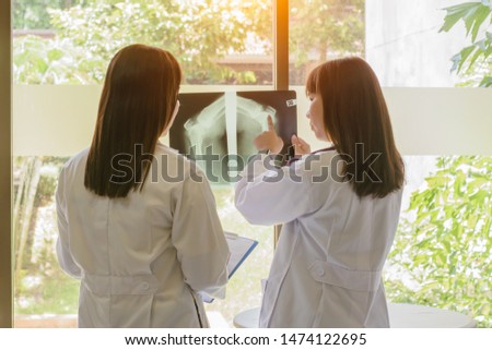 Female doctor dicussion  and examining  X-ray at office