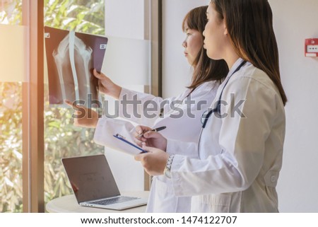Female doctor dicussion  and examining  X-ray at office
