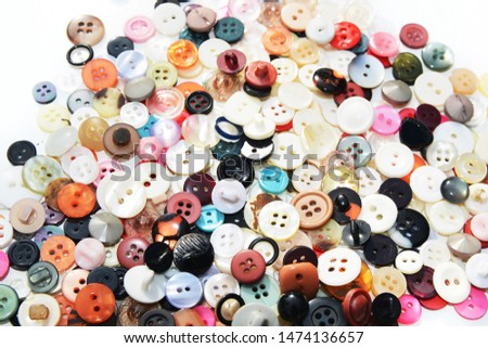 Multi-colored sewing buttons of different sizes and shapes on isolated background