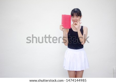 Portrait of thai adult beautiful girl black shirt white skirt and red book