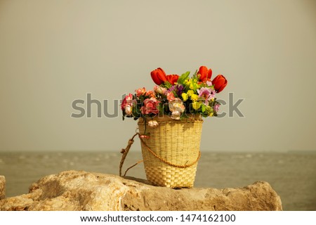 Flower basket placed on the rocks by the sea