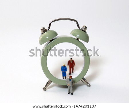 Miniature people walking out of the clock. The concept of old age and retirement. Royalty-Free Stock Photo #1474201187