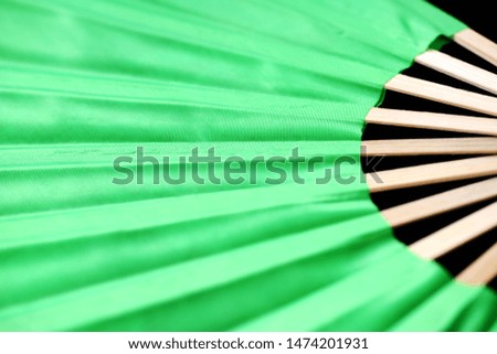 Bright vietnamese fan spread out on a dark background close-up