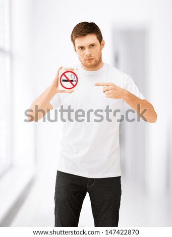 picture of young man pointing at no smoking sign