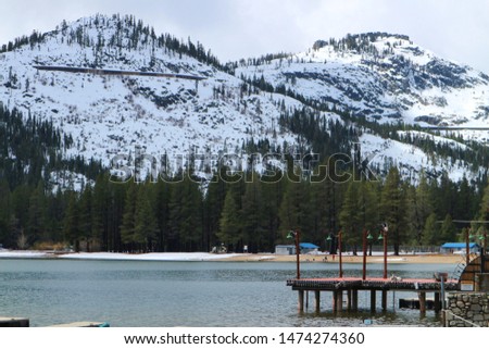 Wooden pier in the lake with mountains view background during winter