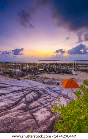 Beautiful sunrise moment in wonderful beach with orange tent. This photo take in the one of beautiful beach Bintan Island Indonesia.