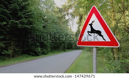 forest and road signs at roadside "animal crossing" Royalty-Free Stock Photo #147429671