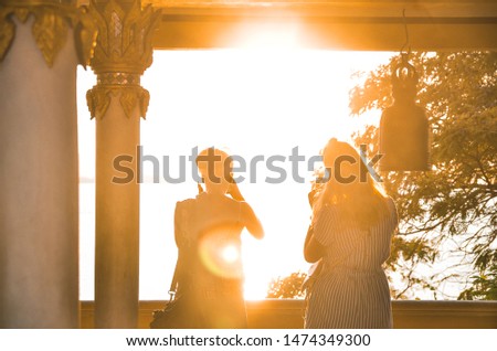 2 girls watching the beautiful sunset, Koh Samui, Thailand.