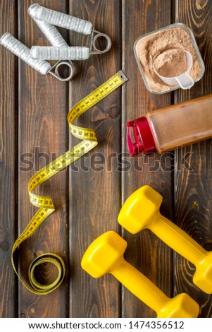 Sports nutrition and fitness tools on wooden background top view