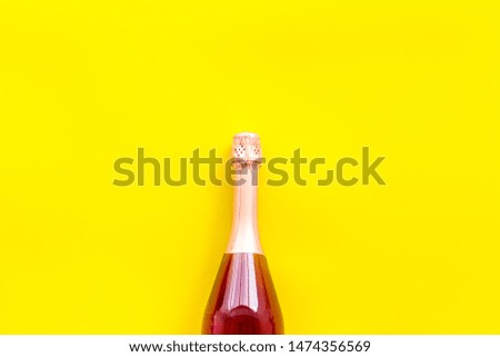 Party concept with champagne bottle on yellow background top view copyspace