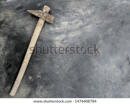 The hammer on the handle is an old wood placed on a polished cement.