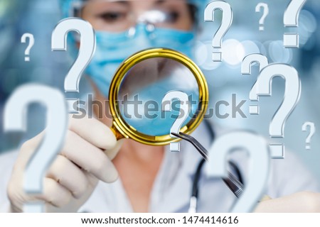 The concept of searching for the right diagnosis of the patient. Doctor look at the question mark through a magnifying glass.