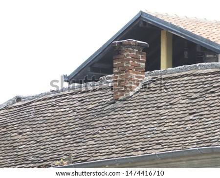 an old house roof with old plates and a chimney