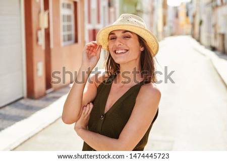 Stunning smile on sunhat girl standing in street, portrait