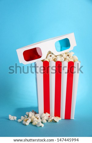 Popcorn and 3D glasses on blue background