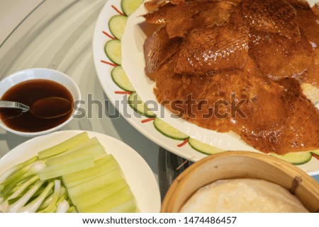 Asian Chinese food tradition. Thailand restaurant style. Peking Duck (Beijing duck) Roasted duck with leather Eat with flour Spring onion Fresh cucumber and sweet sauce. Restaurant table background