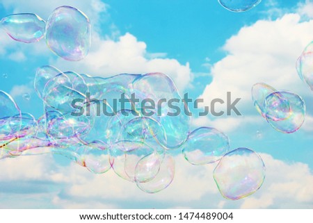 Dreamy Soap Bubbles floating on the breeze in the blue and cloudy sky stock photo background