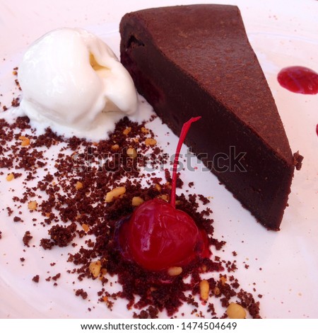 Macro photo chocolate cake with ice cream and cherry. Food product dessert chocolate cake on white platte